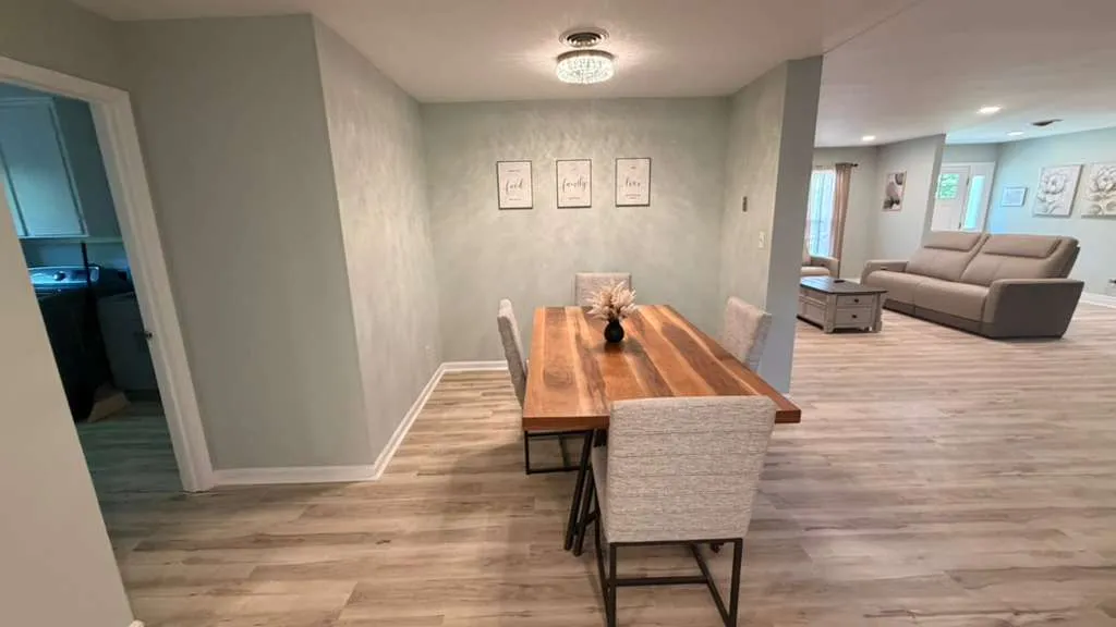 Lower-level dining area with plank flooring, opening to the family room and laundry