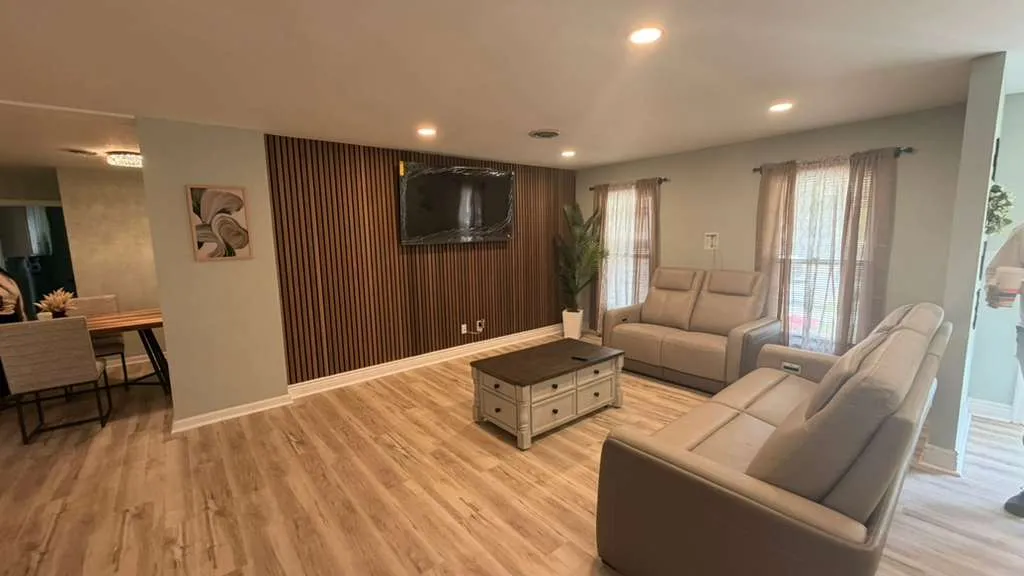 Finished basement family room with a vertical wood slat accent wall and wall-mounted television